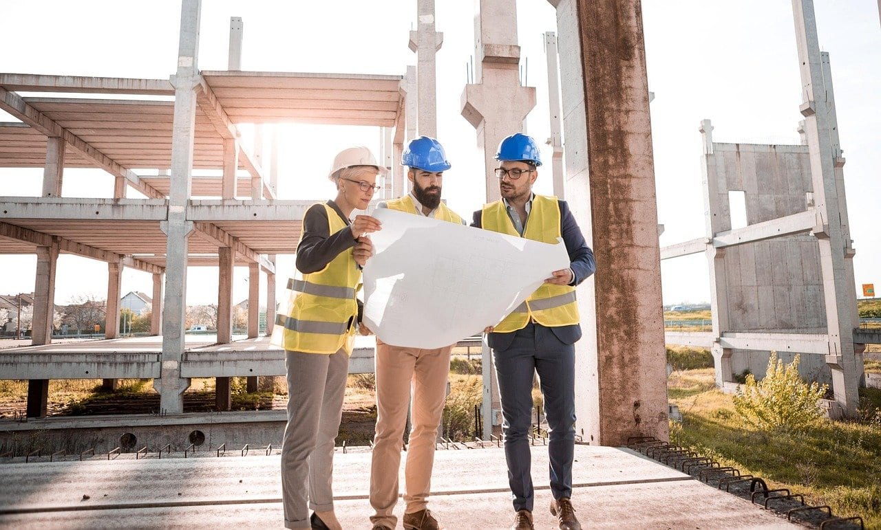 Architect reviewing construction drawings on a site table